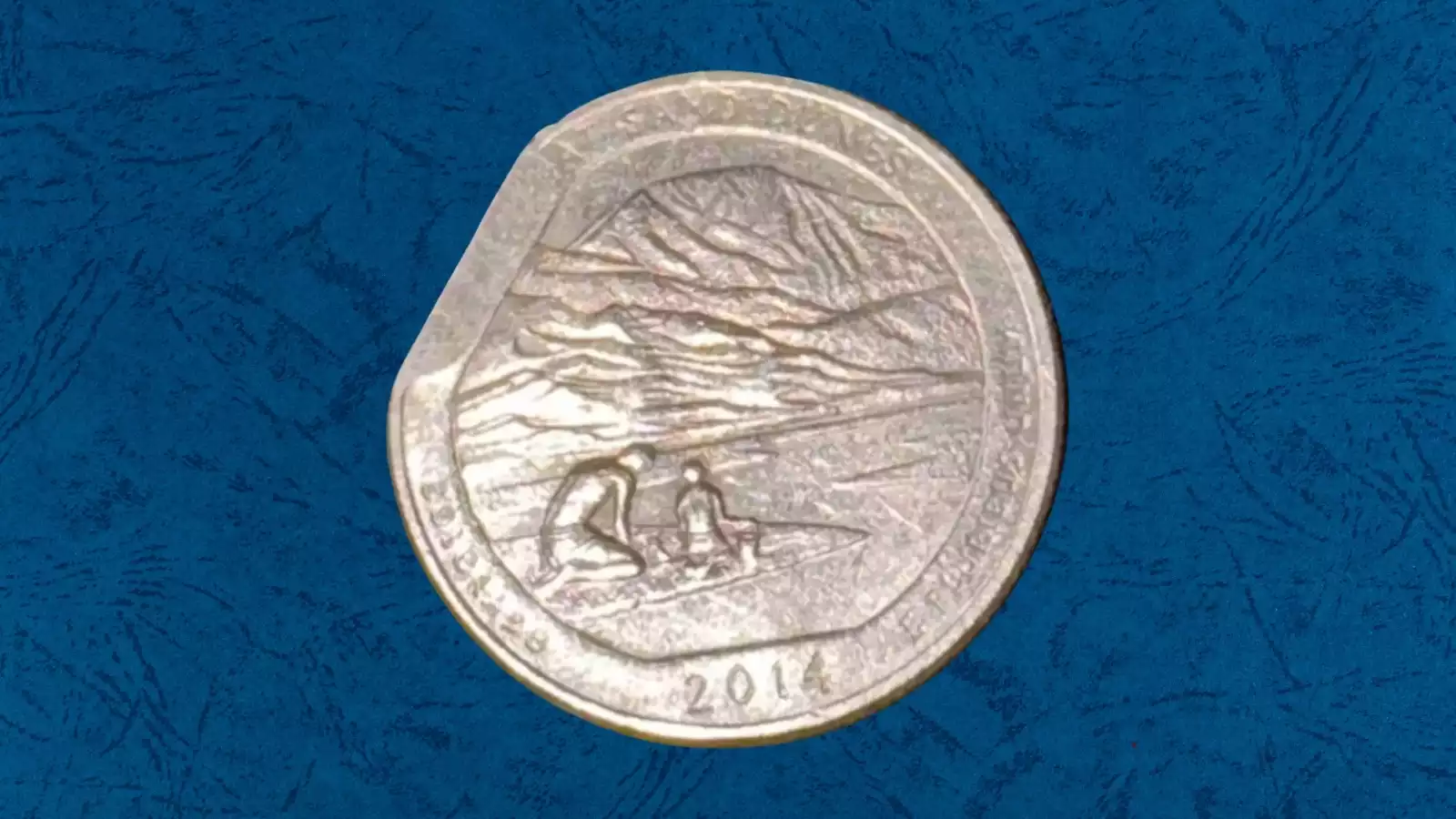2014 quarter clipped planchet error showing missing section of coin edge